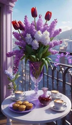 a vase filled with purple flowers sitting on top of a table next to cups and saucers