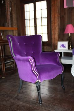 a purple chair sitting on top of a hard wood floor