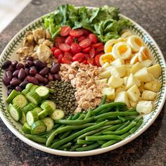 a white plate topped with green beans, cucumbers and other foodstuffs