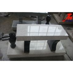 a white marble bench sitting on top of a cement slab next to other pieces of equipment