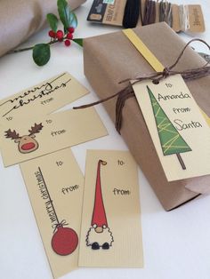 christmas gift tags are tied with twine and sitting on a table next to wrapping paper