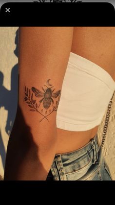 a woman's arm with a bee tattoo on the left side of her body