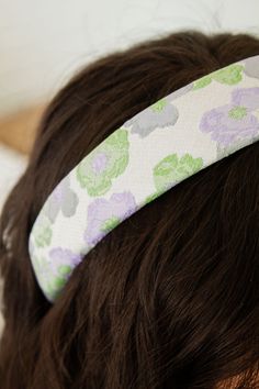 This headband is to die for! Andi is known for its unique and beautiful products and nothing beats our headbands. This is a thick, padded design on a hard band. Made with a fabric that features a large blue, purple and green floral pattern, it will effortlessly match any vibe and any occasion. Bow Ponytail, Green Floral Pattern, Hair Accessories Collection, Padded Headband, Bandana Hairstyles, Pad Design, Branded Gifts, Purple And Green, Wallet Accessories