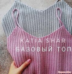 a woman's hand holding onto a pink and grey knitted tank top with the words babobin to it