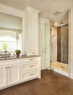 a large bathroom with two sinks and a walk in shower next to a stand up shower