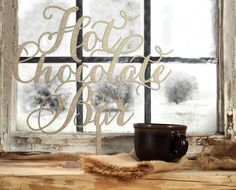 a coffee mug sitting on top of a window sill next to a sign that says hot chocolate bar