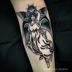 a woman with an angel tattoo on her arm is shown in black and grey ink