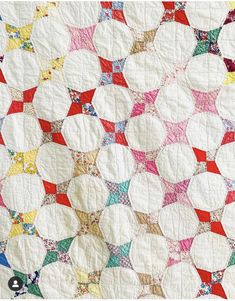 a white quilt with multicolored circles on it