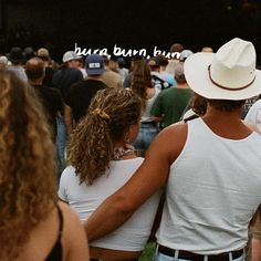 two people standing next to each other in front of a crowd at a music festival