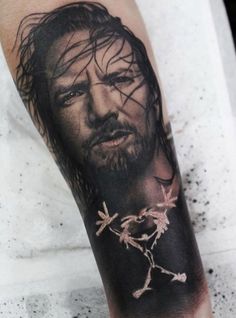 a man's arm with a jesus tattoo on it