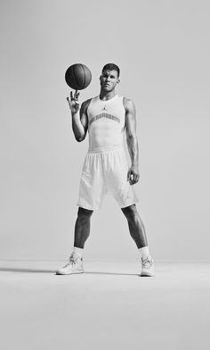 a black and white photo of a man holding a basketball in his right hand while standing