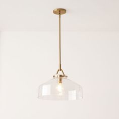 a light fixture hanging from the ceiling in a room with white walls and flooring