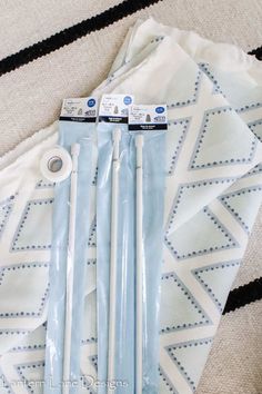 three pairs of blue and white toothbrushes sitting on top of a bed next to each other