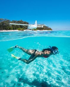 a person swimming in the water near an airplane