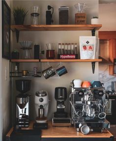 a coffee maker sitting on top of a wooden counter next to a shelf filled with cups