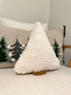 a small white christmas tree sitting on top of a bed