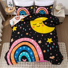 a bed with a black comforter and rainbows, stars, and clouds on it