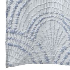 a white and blue pillow with an intricate design on the front, in shades of light blue