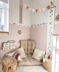 a child's room with pink walls and white furniture