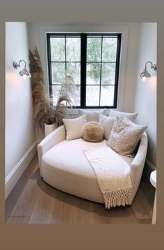 a white couch sitting in front of a large window