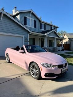 a pink bmw convertible parked in front of a house