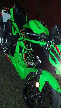 a green motorcycle parked on the street at night