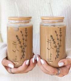 two women holding jars with plants drawn on them