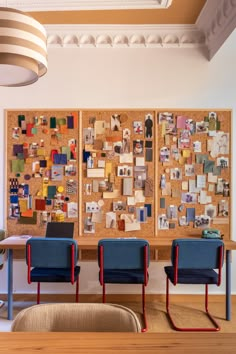 three chairs are in front of a cork board with pictures on it