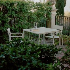 an outdoor table and chairs in the garden