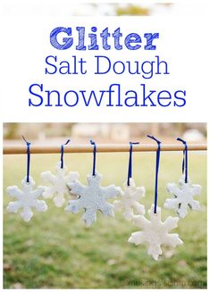 homemade salt dough snowflakes hanging from a clothes line with text overlay that reads, glitter salt dough snowflakes