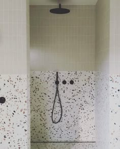 a bathroom with a shower head and tiled walls