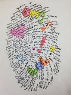 an art project with words written in different colors and shapes on white paper, including hearts