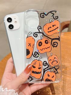 someone holding up their phone case with halloween stickers on it