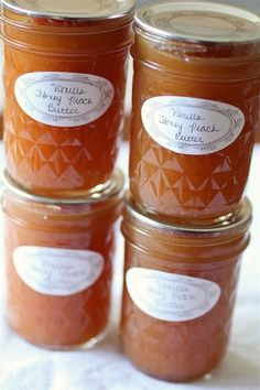 four jars filled with jam sitting on top of a table