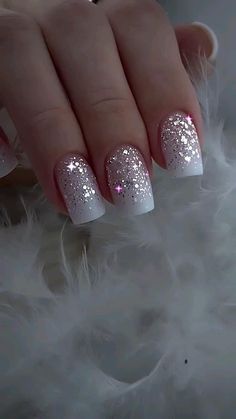 a woman's hand with white and silver glitter nails