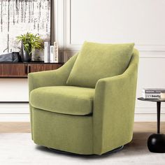 a living room with a green chair next to a coffee table and potted plant