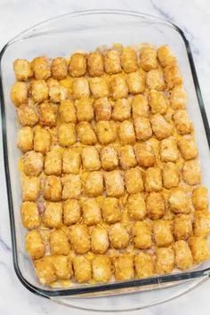 tater tots in a glass casserole dish on a marble countertop