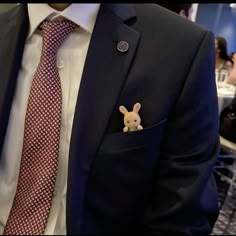 a man wearing a suit and tie with a lapel pin on his lapel