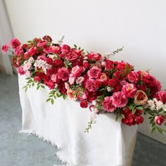 a bunch of flowers that are on top of a white table cloth and in front of a door