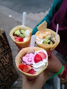 three ice cream sundaes with strawberries and chocolate chips