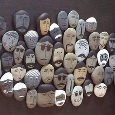 some rocks with faces painted on them and one has a mustache in the middle, while others have different facial expressions