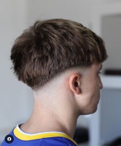 a young boy with a short haircut in front of a computer monitor and keyboard