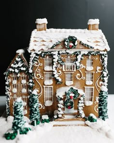 a gingerbread house with decorations on the roof and windows is shown in the snow