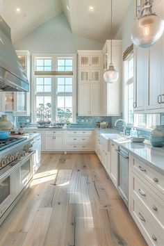 a large kitchen with white cabinets and wood floors