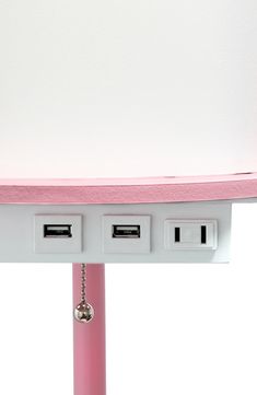 a pink and white shelf with three plugs attached to the top of each outlet