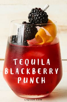 a red drink with blackberries and oranges in it