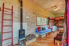 a living room filled with furniture and a fire place in the middle of a wooden floor