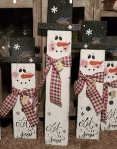 three snowmen made out of wooden blocks