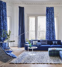 a living room filled with furniture and blue curtains