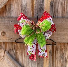 a green and red christmas bow hanging on a wooden door